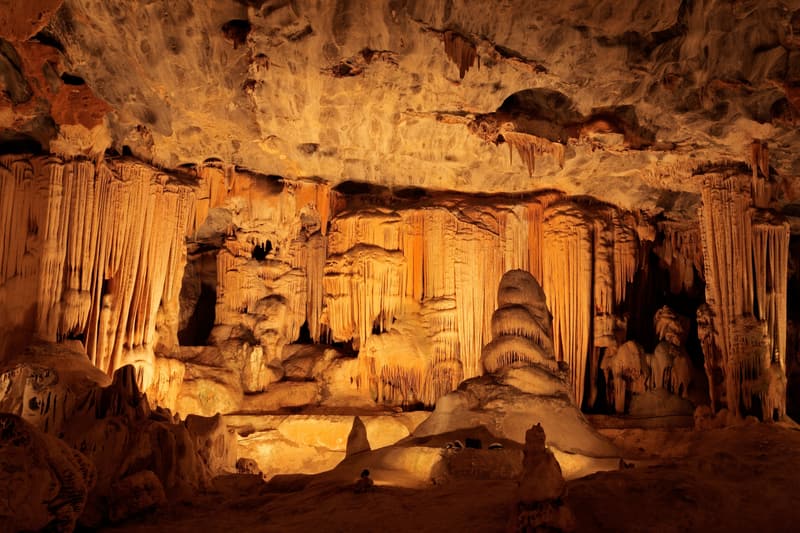 Tropfsteinformationen in einer Höhle, von warmem Licht angestrahlt
